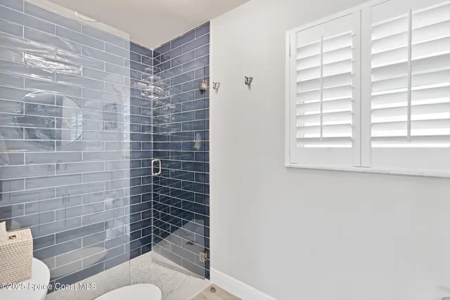 a bathroom with a toilet and a shower