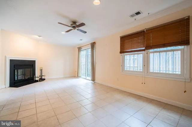 a view of an empty room with a fireplace and a window