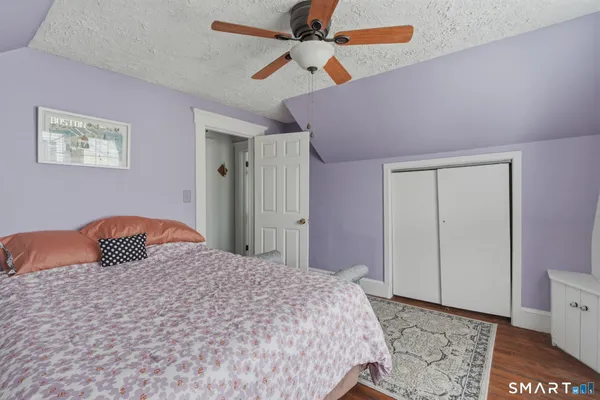 a bedroom with a bed and a painting on the wall