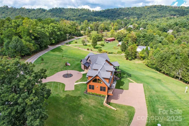 an aerial view of a house with a yard and lake