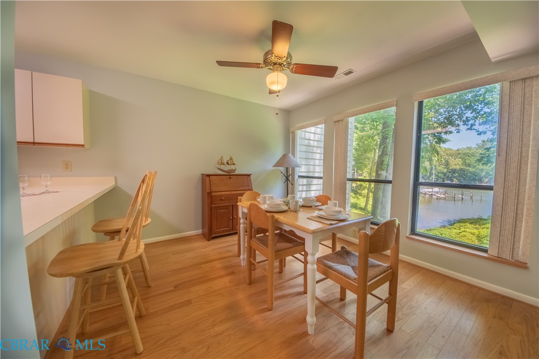 54 Villa Ridge Drive, Unit C Hartfield, VA 23071 - Photo 45 of 45 Dining room featuring light wood-type flooring, a water view, and ceiling fan
