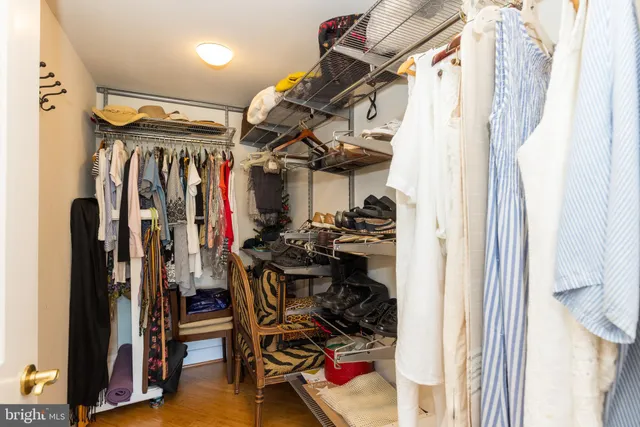 a view of walk in closet with clothes and shoes