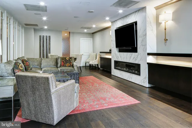 a living room with furniture wooden floor and a large window
