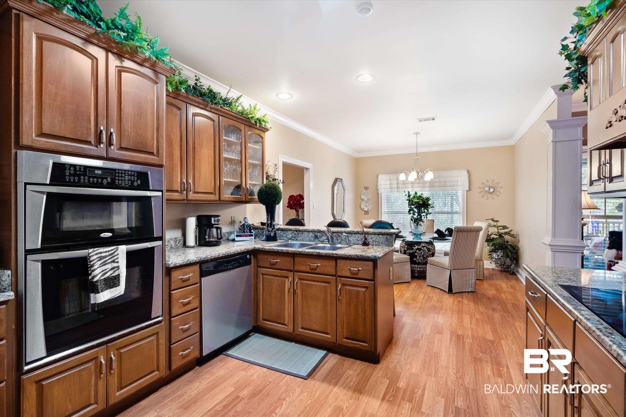 2400 Waterford Road Semmes, AL 36575 - Photo 9 of 30 Kitchen featuring stainless steel appliances, light wood-style flooring, a peninsula, healthy amount of natural light, and ornamental molding