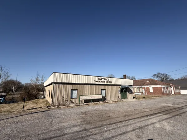 a view of a big house with wooden fence