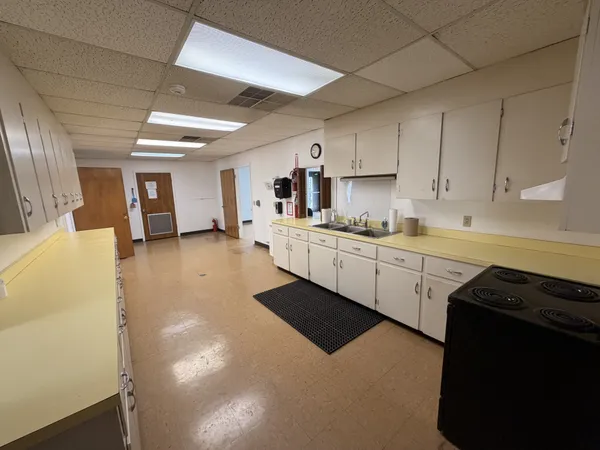 a kitchen with a sink a stove and cabinets