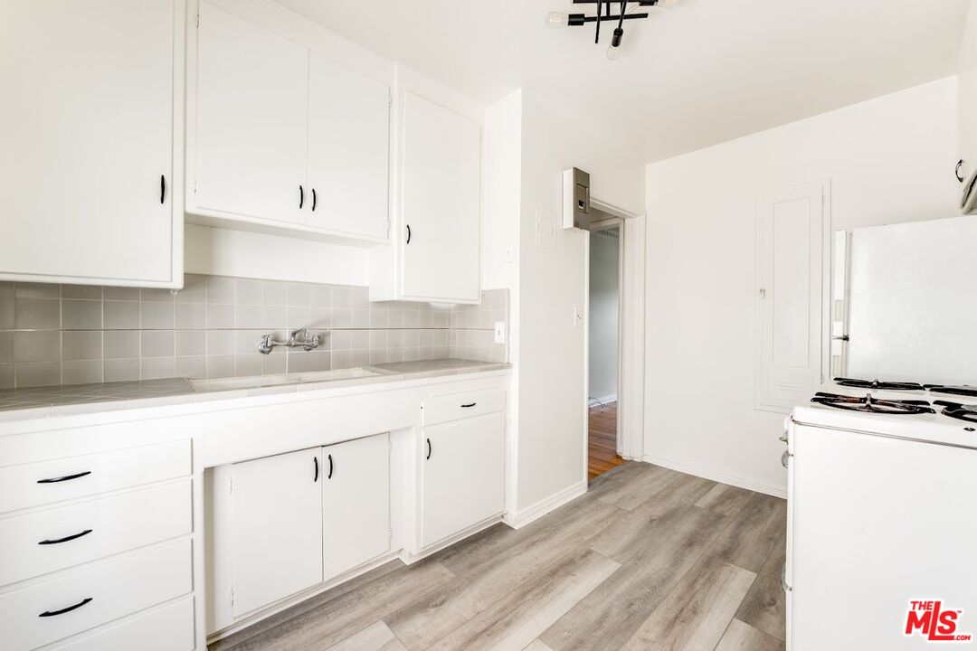 1706 North Stanley Avenue, Unit 2 Los Angeles, CA 90046 - Photo 6 of 10 a kitchen with granite countertop white cabinets and white appliances