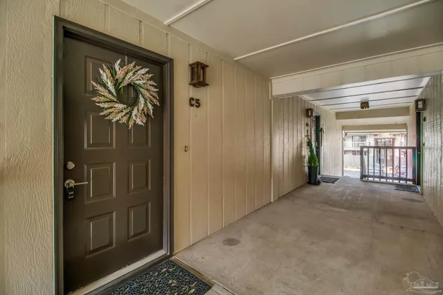 a view of a hallway with wooden floor and a door