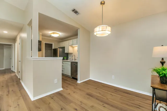 a view of a kitchen with wooden floor and a window