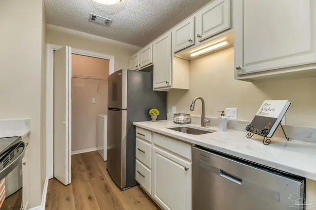 a kitchen with stainless steel appliances granite countertop a sink and a refrigerator