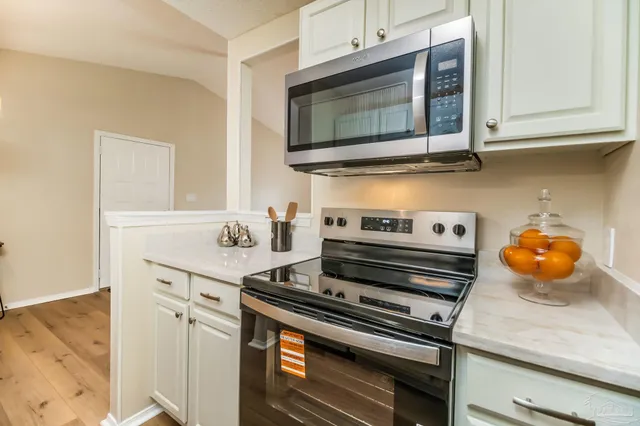 a kitchen with stainless steel appliances granite countertop a stove and a microwave