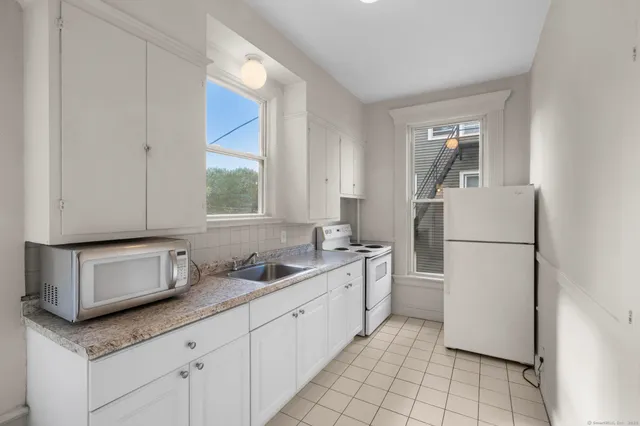 a kitchen with stainless steel appliances granite countertop a sink and a refrigerator
