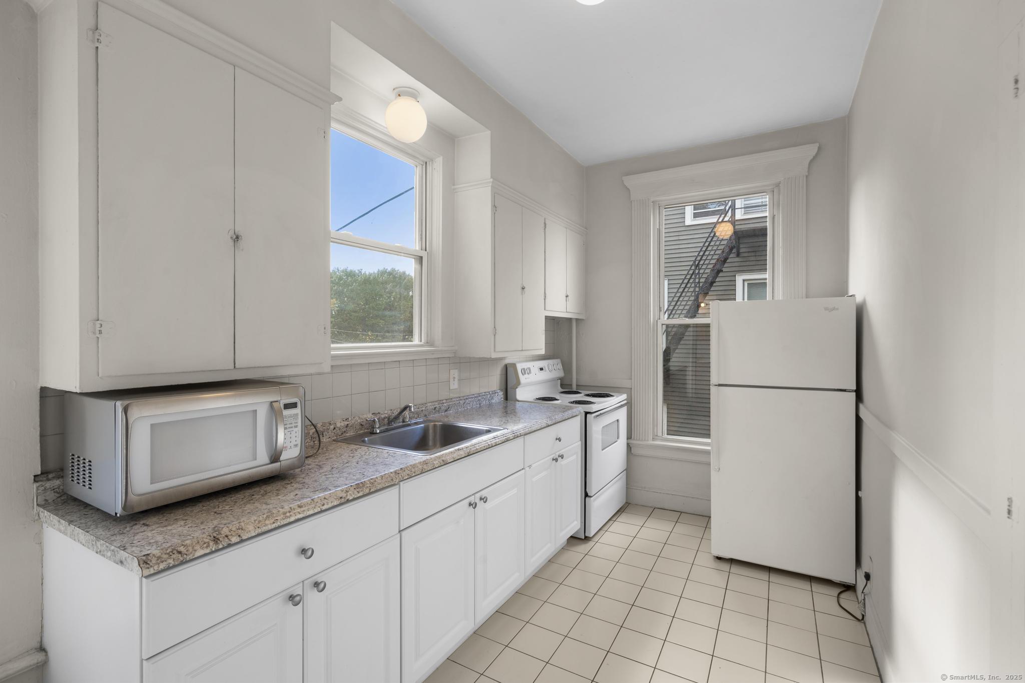 a kitchen with stainless steel appliances granite countertop a sink and a refrigerator