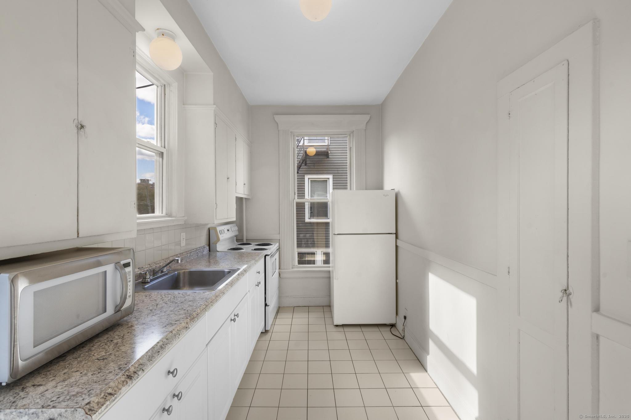 113 East Main Street, Unit 5 Meriden, CT 06450 - Photo 2 of 21 a large white kitchen with a stove a refrigerator and a sink