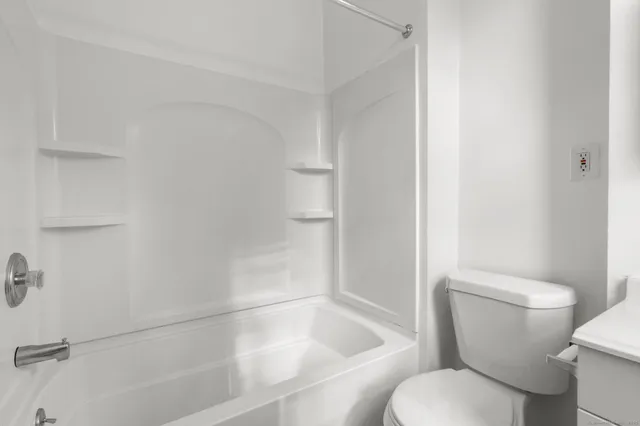 a white toilet sitting next to a bath tub