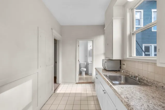 a spacious bathroom with a granite countertop sink and a mirror