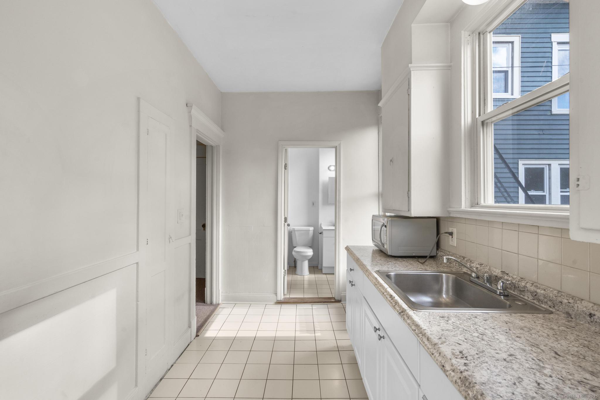 113 East Main Street, Unit 5 Meriden, CT 06450 - Photo 6 of 21 a spacious bathroom with a granite countertop sink and a mirror