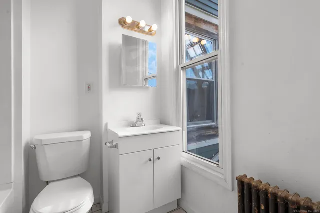 a white toilet sitting next to a bathroom sink