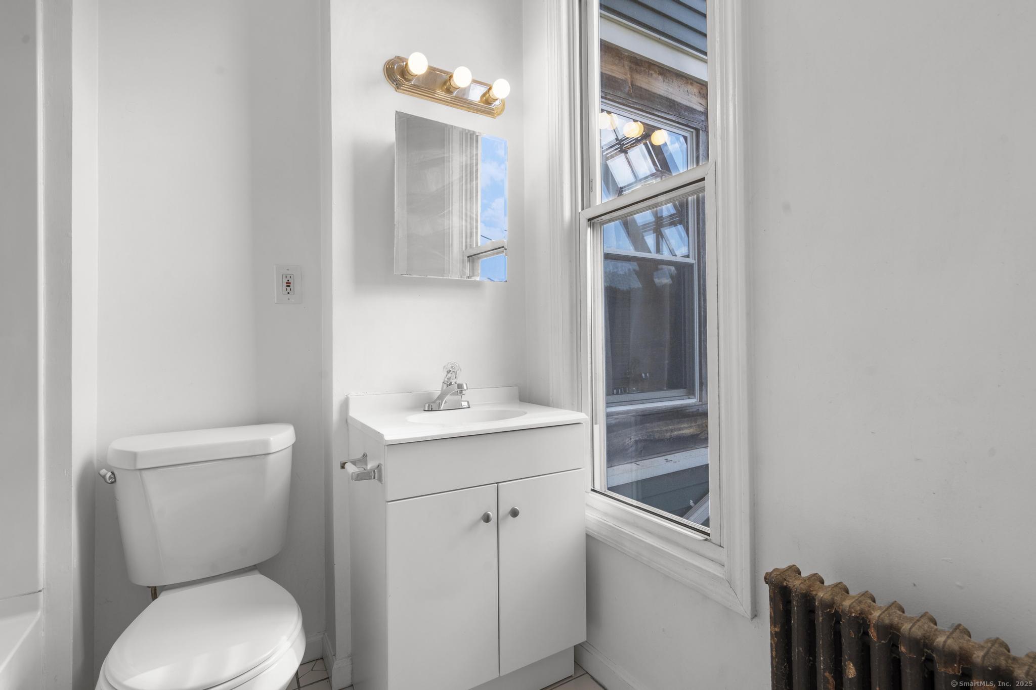 113 East Main Street, Unit 5 Meriden, CT 06450 - Photo 7 of 21 a white toilet sitting next to a bathroom sink
