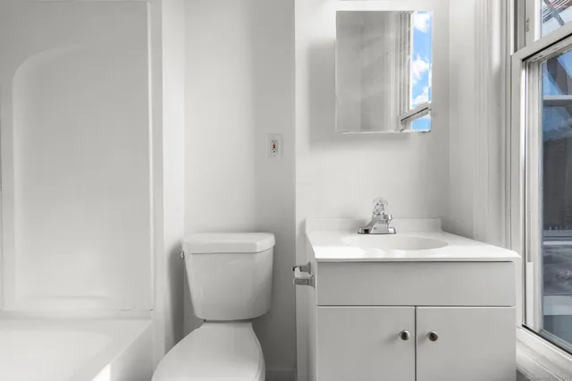 a bathroom with a toilet sink and mirror