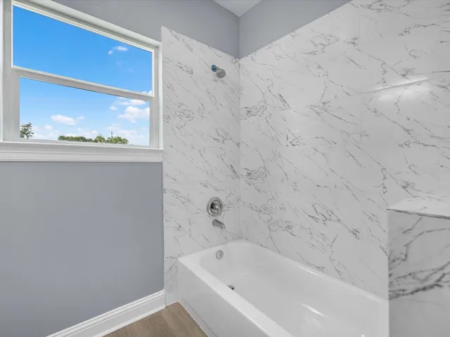 a bathroom with a bathtub and shower