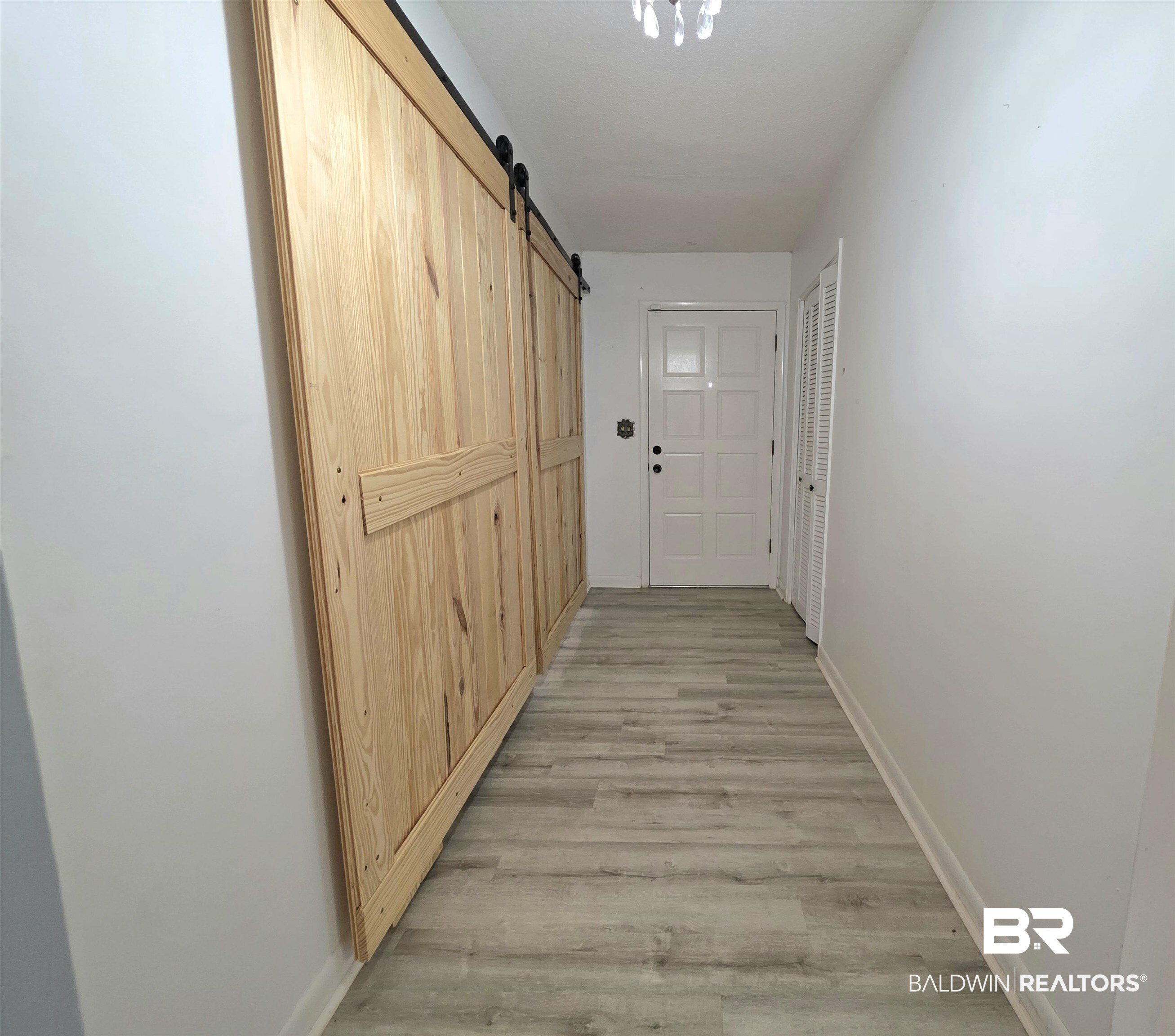 558 Stanton Road Atmore, AL 36502 - Photo 11 of 29 Hallway featuring light wood-finish flooring and white walls