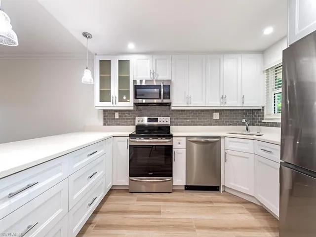 a kitchen with granite countertop white cabinets and appliances