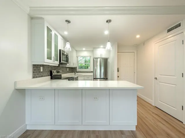 a kitchen with kitchen island sink stove and refrigerator