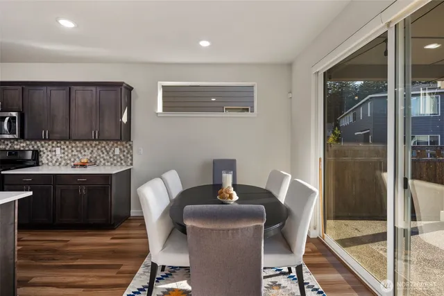 a kitchen with granite countertop a dining table chairs and a refrigerator