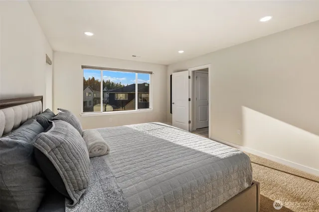 a bedroom with a large bed and a large window