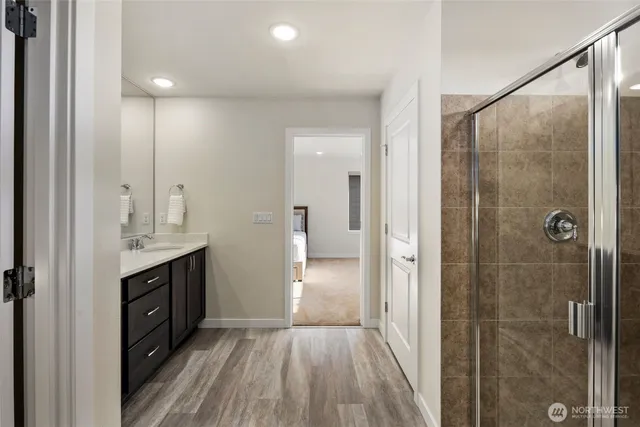 a bathroom with a double vanity sink a toilet and shower