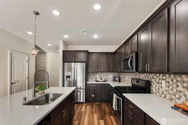 a kitchen with stainless steel appliances granite countertop a sink refrigerator and cabinets