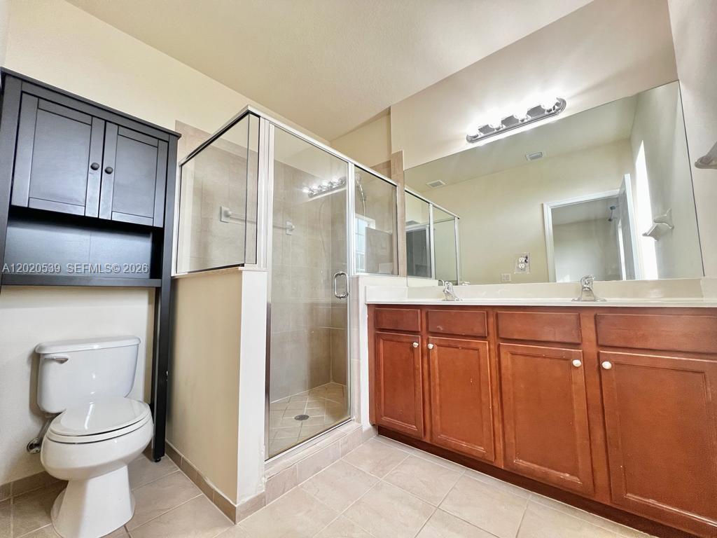 17001 Southwest 96th Street Miami, FL 33196 - Photo 14 of 23 a bathroom with a toilet a sink and a mirror