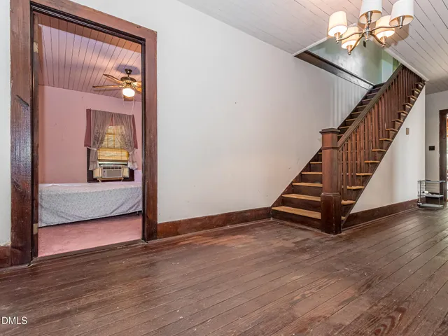 a view of a hallway with wooden floor and staircase