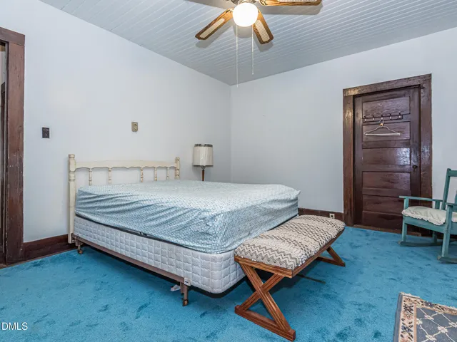 a bedroom with a bed table and chair