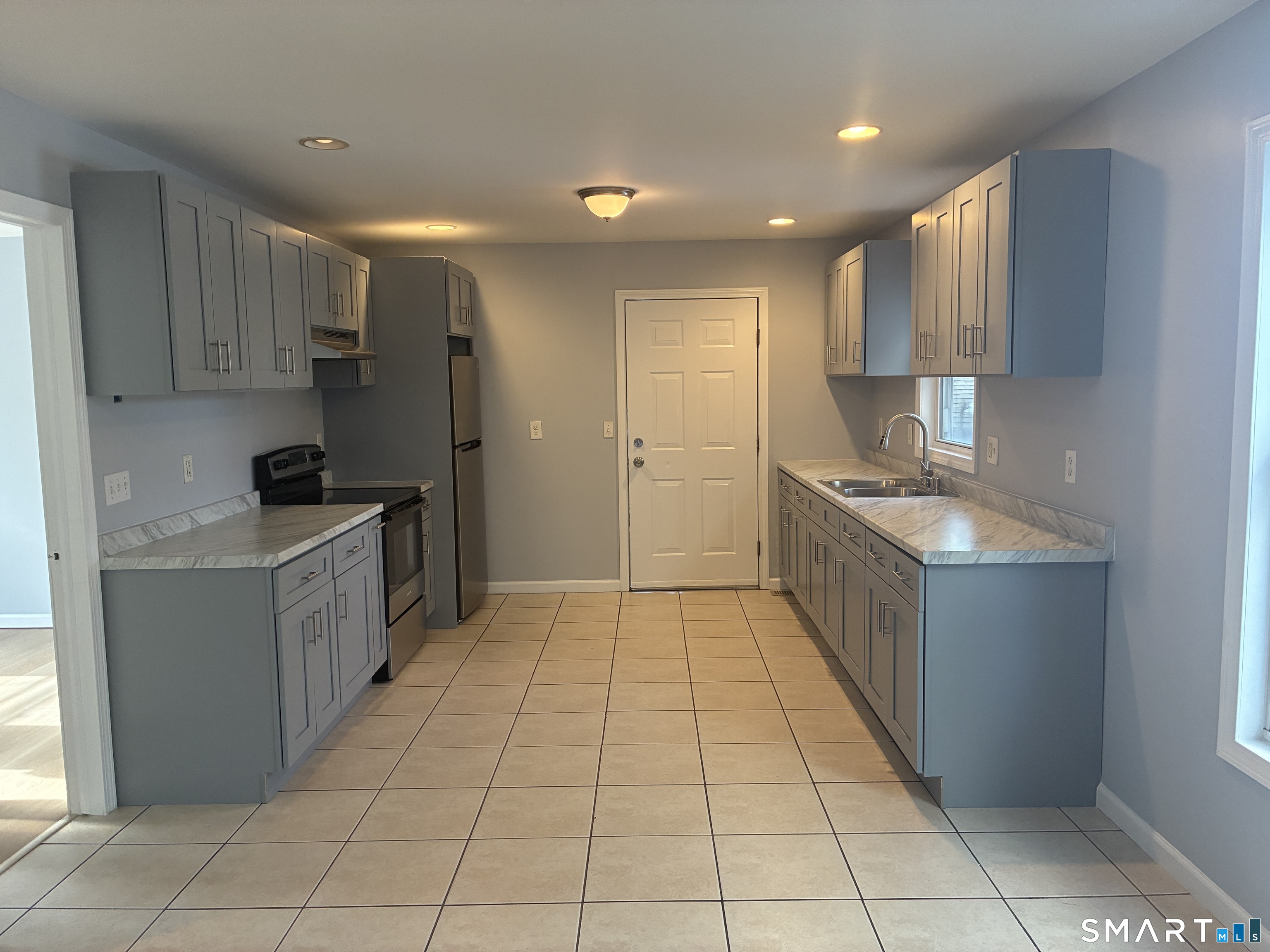 a kitchen with a sink a counter top space cabinets and stainless steel appliances