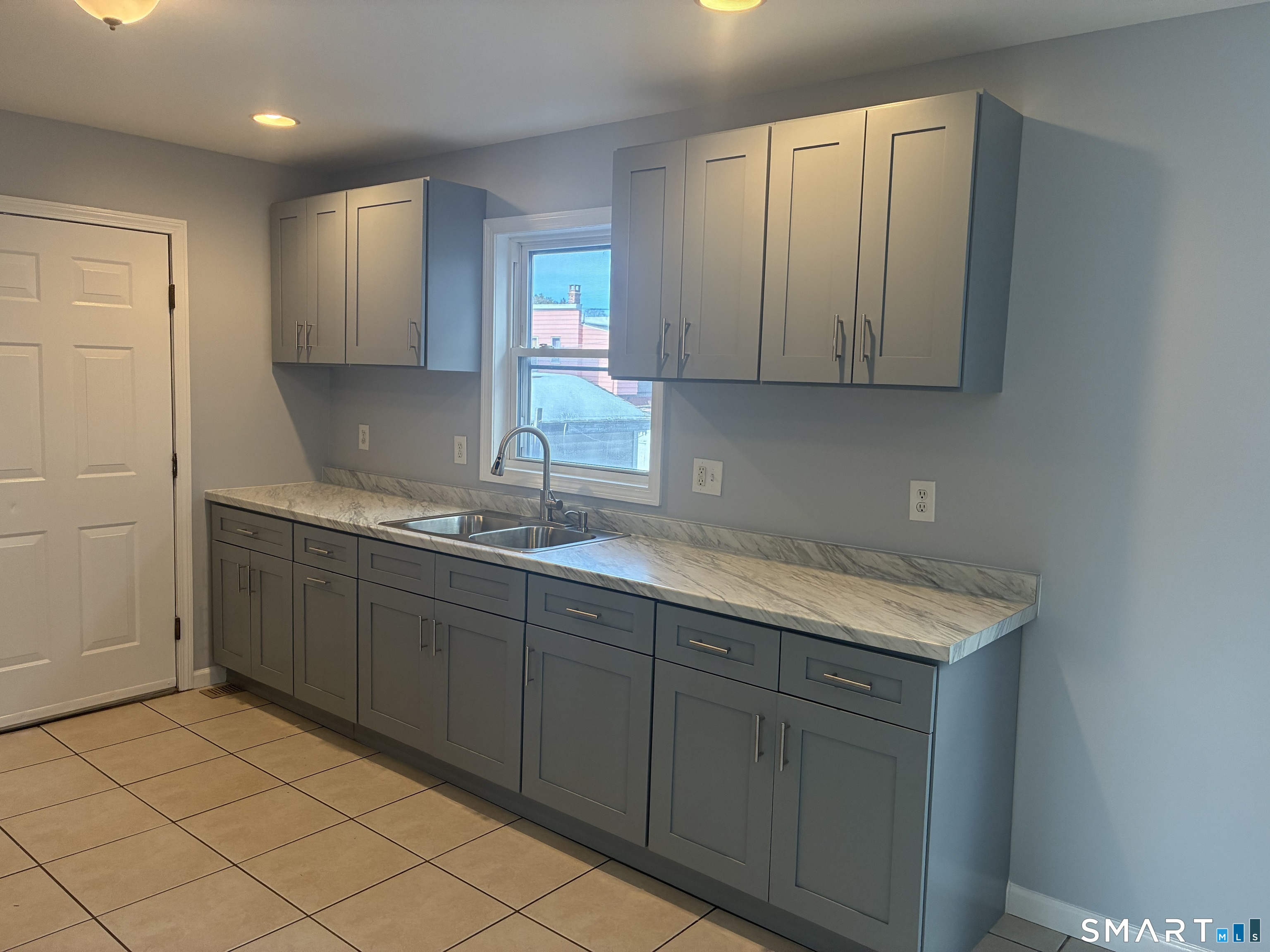 75 Ash Street Bridgeport, CT 06605 - Photo 2 of 9 a kitchen with a sink cabinets and a window