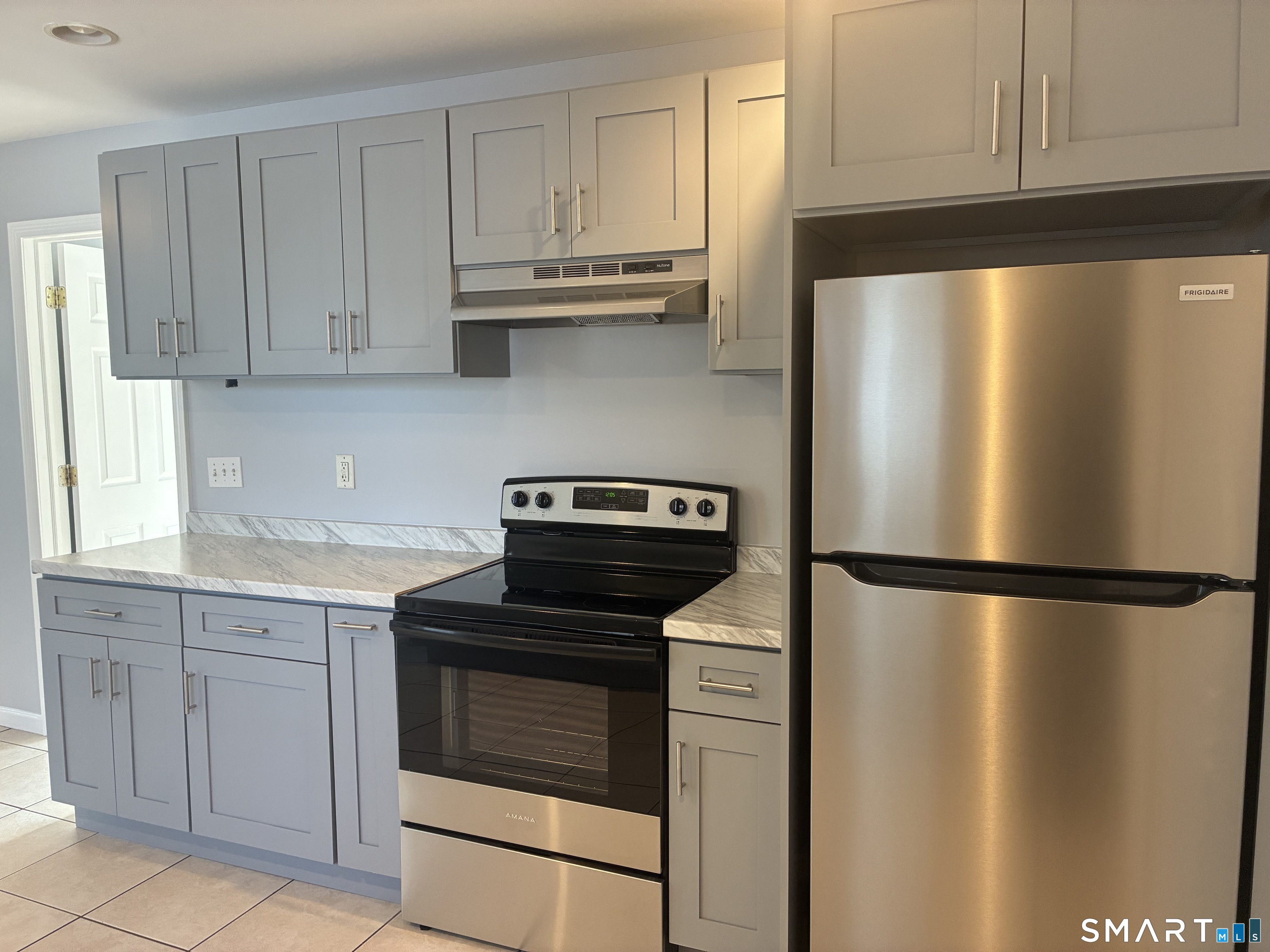 75 Ash Street Bridgeport, CT 06605 - Photo 3 of 9 a kitchen with a refrigerator sink and cabinets