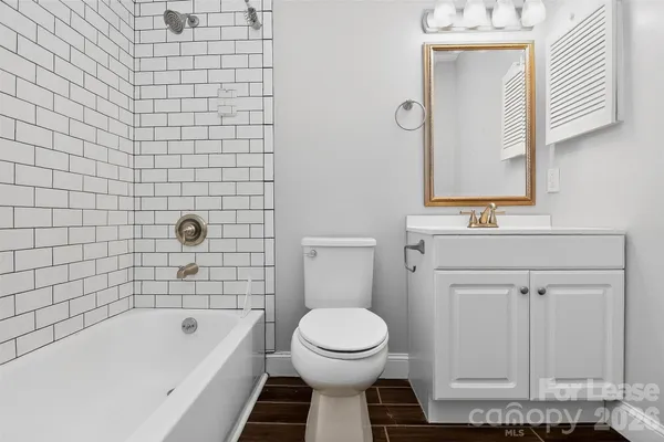 a bathroom with a toilet a sink a mirror and bathtub