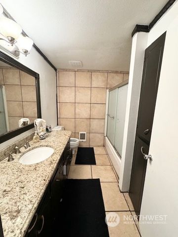 a bathroom with a granite countertop sink and a mirror
