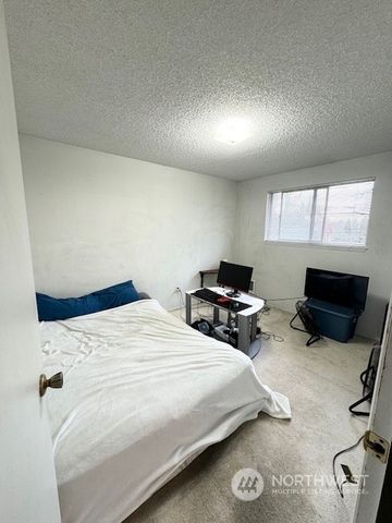 a bedroom with bed tv and window