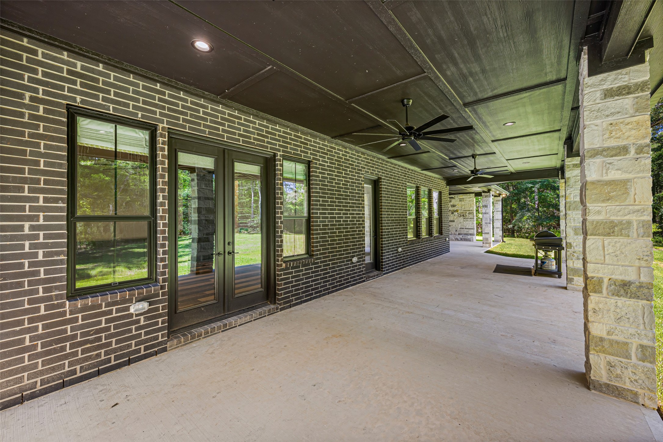 19314 Chateau Ridge Court Tomball, TX 77377 - Photo 41 of 50
Multiple exterior doors open onto an expansive covered patio, creating a seamless transition to the home’s outdoor living spaces.
