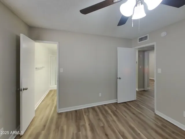 a view of an empty room and chandelier fan