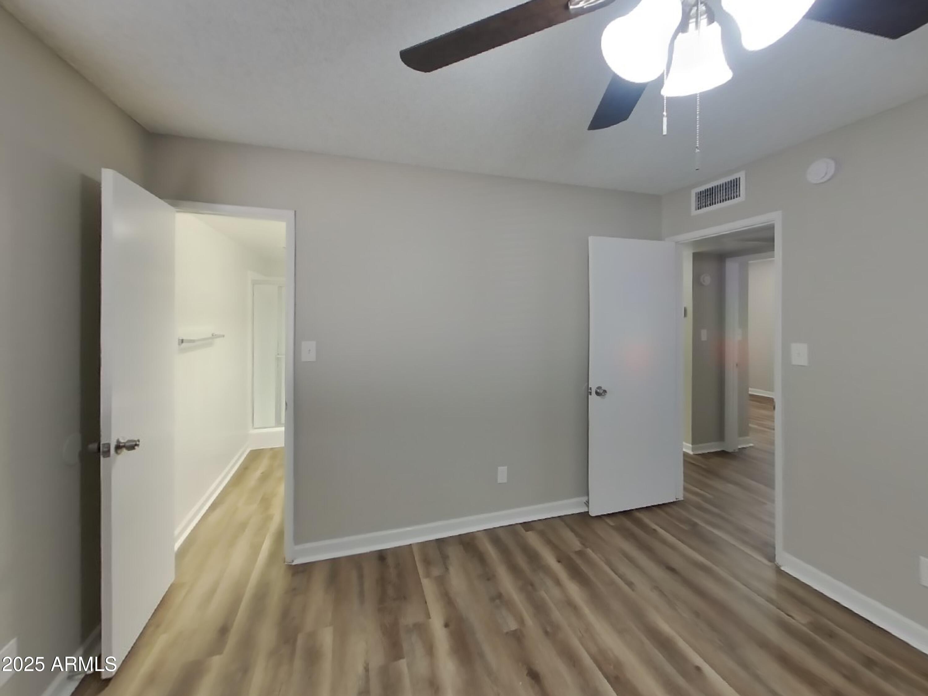 8948 West Heatherbrae Drive Phoenix, AZ 85037 - Photo 10 of 21 wooden floor in an empty room with a window