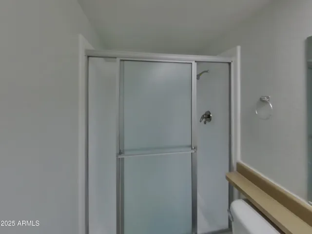 a bathroom with a granite countertop sink a toilet and shower
