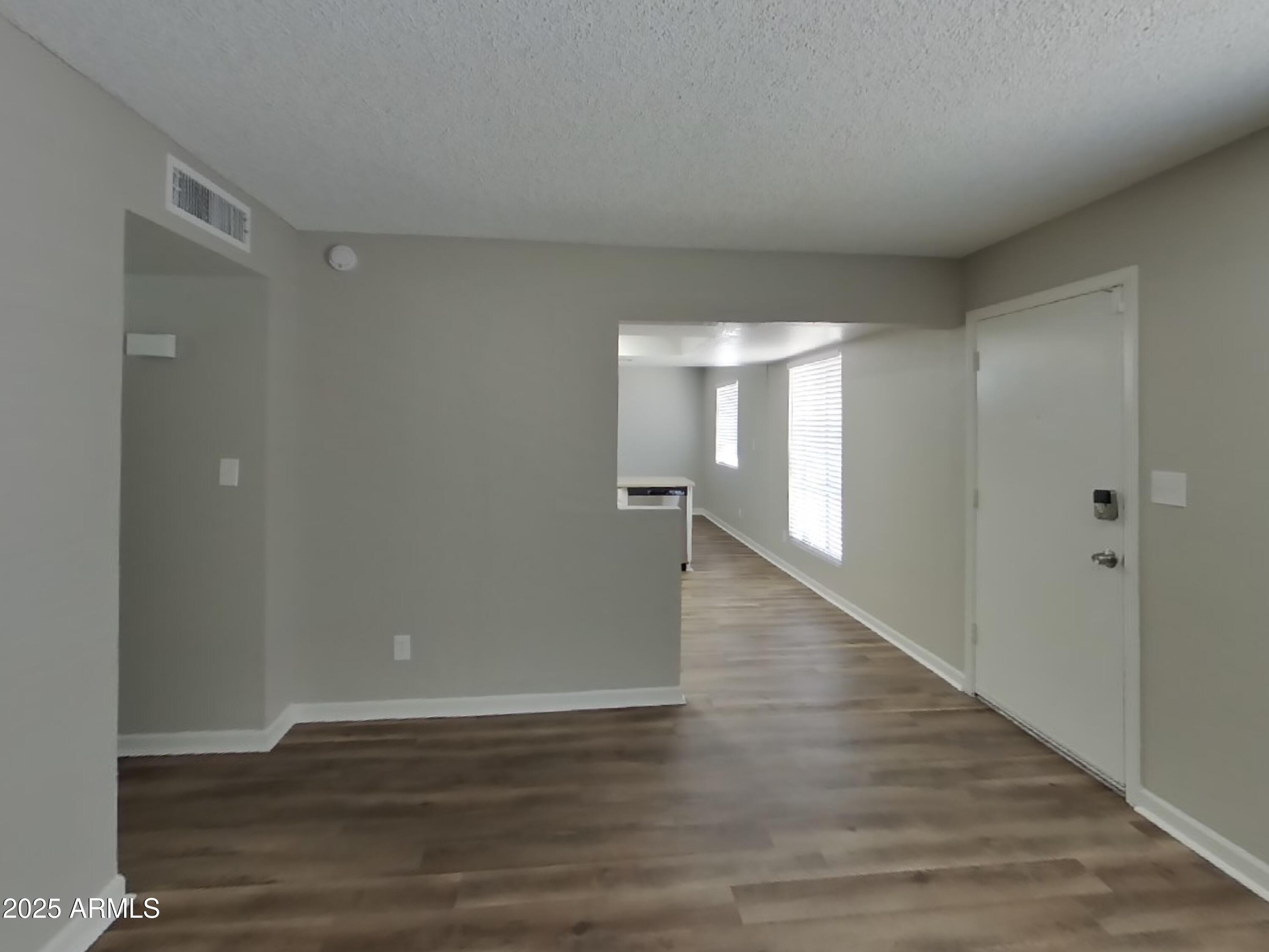 8948 West Heatherbrae Drive Phoenix, AZ 85037 - Photo 4 of 21 a view of an empty room with wooden floor