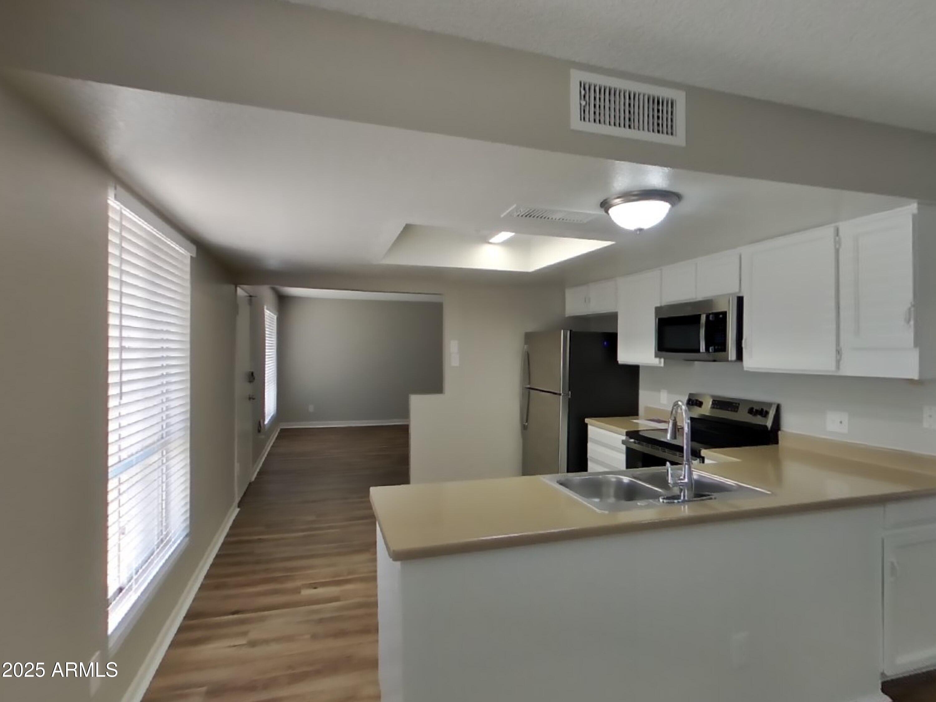8948 West Heatherbrae Drive Phoenix, AZ 85037 - Photo 7 of 21 a kitchen with stainless steel appliances a sink stove and cabinets