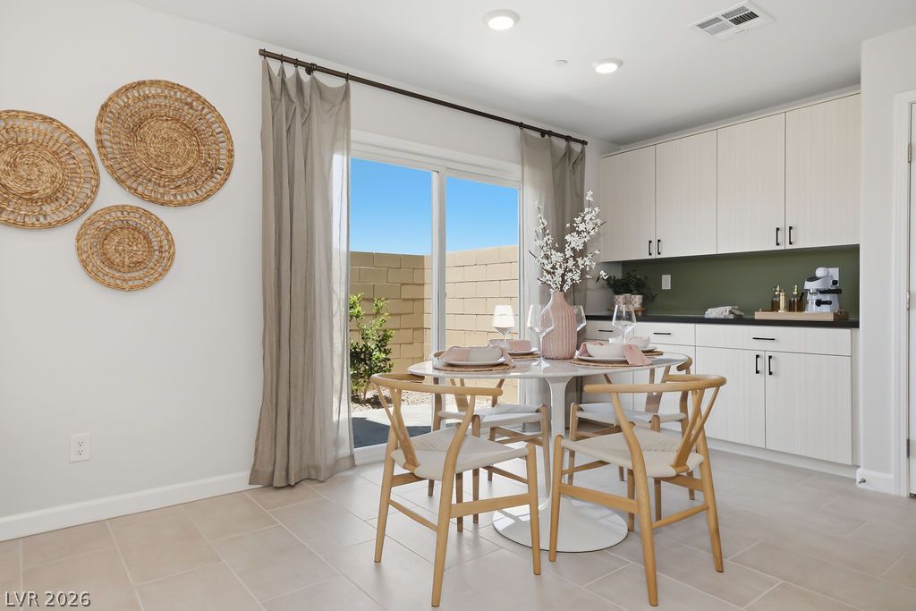 913 Cadence View Way Henderson, NV 89011 - Photo 14 of 46 A well-lit dining area offers direct outdoor access through sliding glass doors.