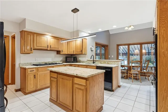 a kitchen with stainless steel appliances granite countertop a stove a sink a oven with a dining table and chairs