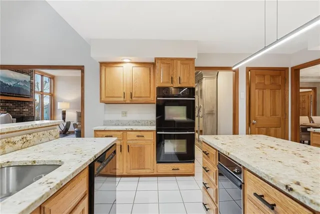 a kitchen with granite countertop a sink stove and refrigerator
